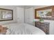 Bedroom with white bedding, side table, and ornate mirror with orchids at 9231 E Carmel Ave, Mesa, AZ 85208