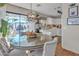 Stylish dining area with a glass-top table, comfortable seating, and a view of the outdoor patio at 9231 E Carmel Ave, Mesa, AZ 85208