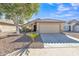 Inviting single-story home with desert landscaping, a mature shade tree, and a neutral-toned facade with a tiled roof at 9231 E Carmel Ave, Mesa, AZ 85208