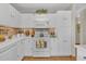 Bright kitchen featuring white cabinetry, light countertops, modern appliances, and stylish backsplash at 9231 E Carmel Ave, Mesa, AZ 85208