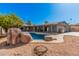 Gorgeous backyard featuring sparkling blue pool, complemented by desert landscaping for serene outdoor enjoyment at 1002 W Fairway Dr, Mesa, AZ 85201