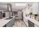 Bright open kitchen features stainless appliances, tile backsplash, skylight, and wood flooring at 1002 W Fairway Dr, Mesa, AZ 85201