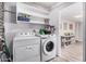 Well-organized laundry room with washer, dryer, and shelving for storage at 1002 W Fairway Dr, Mesa, AZ 85201