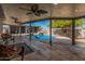 Covered patio overlooks the pool with rock waterfall feature and fruit trees at 1002 W Fairway Dr, Mesa, AZ 85201
