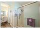 Bathroom doorway view showcases a glass-door shower and a vanity with access to a dressing area at 10417 W Deanne Dr, Sun City, AZ 85351