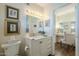 Bathroom featuring a white vanity, decorative art, and doorway leading to the ensuite dressing area at 10417 W Deanne Dr, Sun City, AZ 85351