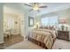 Bright bedroom with ceiling fan and an ensuite bathroom featuring stylish decor, inviting relaxation and convenience at 10417 W Deanne Dr, Sun City, AZ 85351