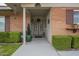 Charming home entrance with brick facade, manicured hedges, and a welcoming front door and porch at 10417 W Deanne Dr, Sun City, AZ 85351