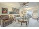 Comfortable living room featuring a plush recliner, soft carpet, and view into the kitchen at 10417 W Deanne Dr, Sun City, AZ 85351