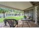 Inviting covered patio with comfortable wicker furniture overlooking a lush green lawn and mature trees at 10417 W Deanne Dr, Sun City, AZ 85351