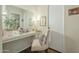 Brightly lit vanity featuring a mirror, white countertop, decorative fixtures, and a comfortable chair at 10417 W Deanne Dr, Sun City, AZ 85351