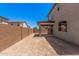 Unlandscaped backyard has a covered patio and a block wall for privacy at 11611 W Green Dr, Youngtown, AZ 85363