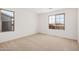 A large bedroom with two windows and beige carpet and neutral walls at 11611 W Green Dr, Youngtown, AZ 85363