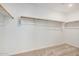 This walk-in closet features wood closet rods and white walls, spacious storage at 11611 W Green Dr, Youngtown, AZ 85363