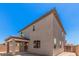 Exterior angle showcases the home's stucco siding, roofline, and covered patio in the backyard at 11611 W Green Dr, Youngtown, AZ 85363