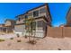 Two-story home featuring a two-car garage, desert landscaping, and neutral color scheme under a clear blue sky at 11611 W Green Dr, Youngtown, AZ 85363