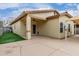 A tan stucco home with a covered patio overlooks a backyard with artificial turf and a concrete patio at 1414 W Alder Rd, Queen Creek, AZ 85140