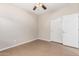 Empty bedroom with white trim, tile flooring, and closet with sliding doors at 1414 W Alder Rd, Queen Creek, AZ 85140