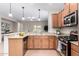 Well-lit kitchen boasting stone countertops, stainless steel appliances, and wood cabinets at 1414 W Alder Rd, Queen Creek, AZ 85140
