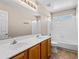 Bathroom featuring a double sink vanity, large mirror, white tiled walls, and shower over tub at 14317 N 78Th Dr, Peoria, AZ 85381