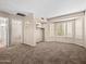 Bedroom with neutral carpet and walls, large window, and closet with built-in shelving at 14317 N 78Th Dr, Peoria, AZ 85381