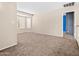 Bedroom featuring neutral carpet and walls, a bright window, and an attached bathroom at 14317 N 78Th Dr, Peoria, AZ 85381
