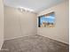 Bedroom featuring neutral carpet and paint, with a large window letting in natural light at 14317 N 78Th Dr, Peoria, AZ 85381