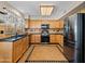 Well-lit kitchen with stainless steel appliances, wood cabinets, and tile flooring at 14317 N 78Th Dr, Peoria, AZ 85381