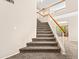 Carpeted staircase features a wood railing and white balusters leading to the second level of the home at 14317 N 78Th Dr, Peoria, AZ 85381