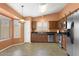 Kitchen with stainless steel appliances, wooden cabinets, and natural light from windows at 14527 W Marcus Dr, Surprise, AZ 85374