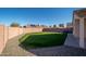Manicured backyard featuring a grassy lawn and a brick privacy fence at 14717 N 130Th Ln, El Mirage, AZ 85335