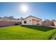 Well-maintained backyard with large grassy area, block fence, and covered patio at 14717 N 130Th Ln, El Mirage, AZ 85335