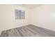 This bright bedroom features a ceiling fan, neutral walls, and updated grey wood-look floors at 14717 N 130Th Ln, El Mirage, AZ 85335