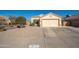 Beige single-story home featuring a two car garage, desert landscaping, and concrete driveway at 14717 N 130Th Ln, El Mirage, AZ 85335