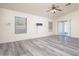 Bright, open living room featuring laminate floors, a ceiling fan, and sliding glass doors at 14717 N 130Th Ln, El Mirage, AZ 85335