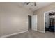 Comfortable bedroom with carpeting, baseboards, ceiling fan, a closet, a white door and neutral paint on the walls at 15239 W Alexandria Way, Surprise, AZ 85379