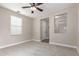 Bright, carpeted bedroom with ceiling fan, neutral paint, and a large window for ample natural light at 15239 W Alexandria Way, Surprise, AZ 85379