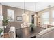 Chic dining room featuring a dark wood table, tufted chairs, and contemporary lighting, creating a cozy atmosphere at 15239 W Alexandria Way, Surprise, AZ 85379