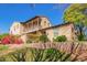 Beautiful home with a charming balcony, desert landscaping, brick retaining wall, and a bright blue sky at 15239 W Alexandria Way, Surprise, AZ 85379