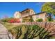 Lovely home with balcony, beautiful red flower bushes, healthy green plants, and a brick retaining wall at 15239 W Alexandria Way, Surprise, AZ 85379