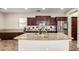 Well-appointed kitchen with granite countertops, dark wood cabinets, stainless steel appliances, and a center island at 15239 W Alexandria Way, Surprise, AZ 85379