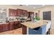 Close-up of the kitchen with granite countertops, an island with seating and stainless steel appliances at 15239 W Alexandria Way, Surprise, AZ 85379