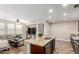 Open concept kitchen and living room area features a large island, stainless steel appliances and cozy living space at 15239 W Alexandria Way, Surprise, AZ 85379