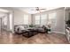 Comfortable living room featuring a ceiling fan, large sofa, and plenty of natural light from the windows at 15239 W Alexandria Way, Surprise, AZ 85379