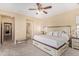 The main bedroom has neutral color palette, ceiling fan, large bed, and ensuite bathroom access at 15239 W Alexandria Way, Surprise, AZ 85379