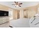 Bright main bedroom with ceiling fan, light-colored walls, and an adjoining bathroom at 15239 W Alexandria Way, Surprise, AZ 85379