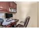 Home office features a wood desk, rolling chair, and built in cabinets at 15239 W Alexandria Way, Surprise, AZ 85379