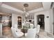 Elegant dining area featuring a glass table, white chairs, and sophisticated lighting at 15802 N 71St St # 501, Scottsdale, AZ 85254