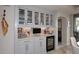 This home features a butler's pantry with illuminated glass cabinetry, wine fridge and stone countertops at 15802 N 71St St # 501, Scottsdale, AZ 85254