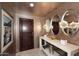 Elegant foyer with decorative mirrors, dark wood door, and a marble console table at 15802 N 71St St # 501, Scottsdale, AZ 85254